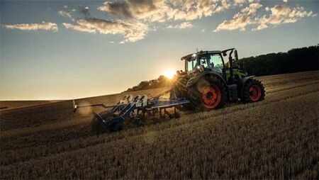 Fendt 600 Vario traktor kører på mark i solnedgang og harver