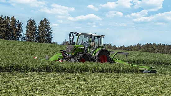 Fendt 300 Vario traktor kører på en græsmark og slår græs